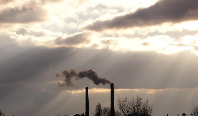 schoorstenen van fabriek in avondlucht