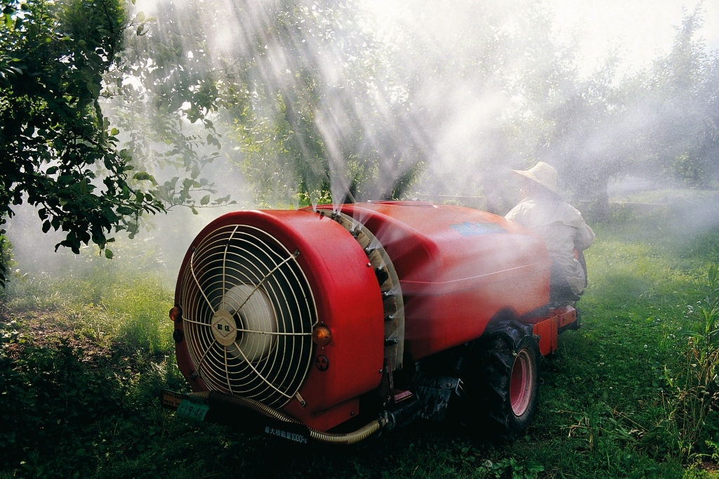 spuittoestel met insecticide in een appelboomgaard 