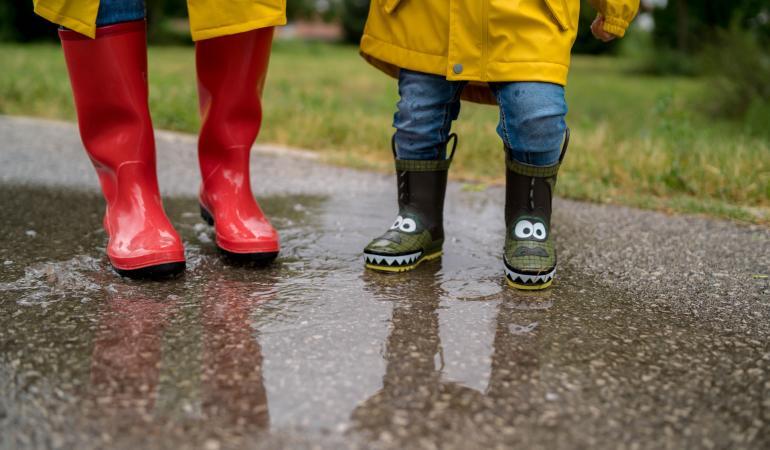 kids met regenlaarsjes in een waterplas