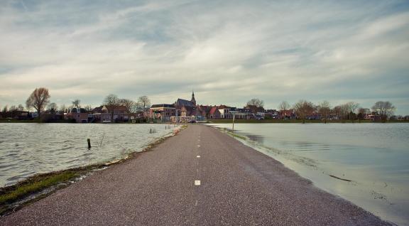 Foto van een weg in Nederland omringt door water 
