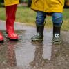 kids met regenlaarsjes in een waterplas